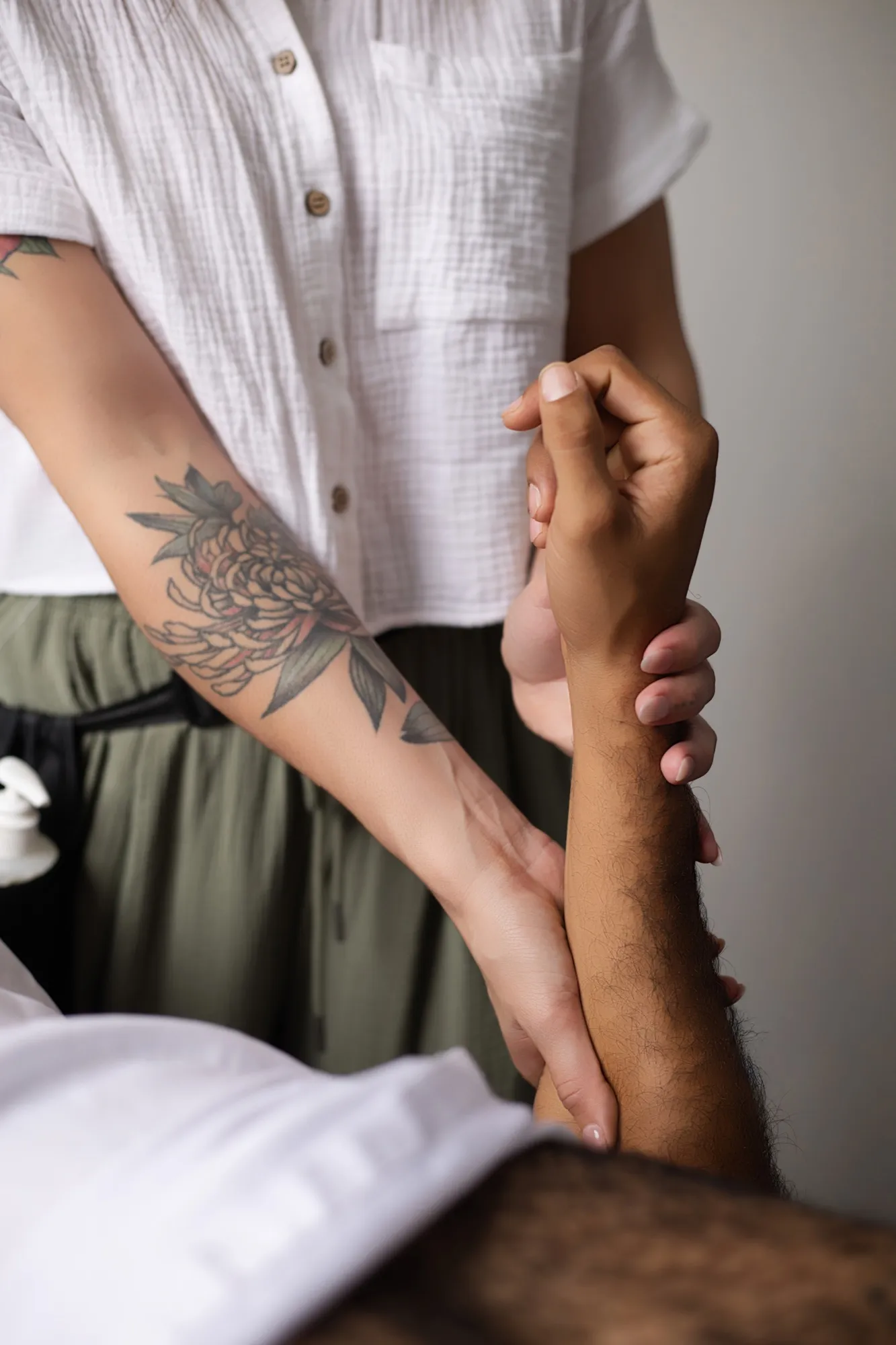 An assisted arm stretch being performed during a massage session