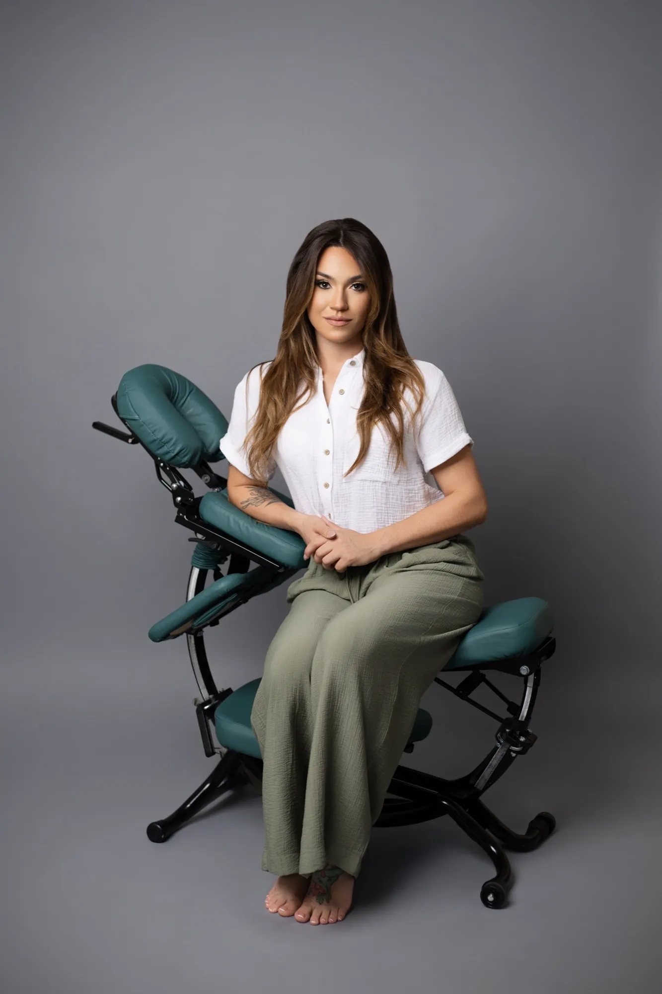 Skylar seated beside her portable massage chair